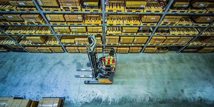 Raben Warehouse with a forklift driver, which lifts the goods on the shelf