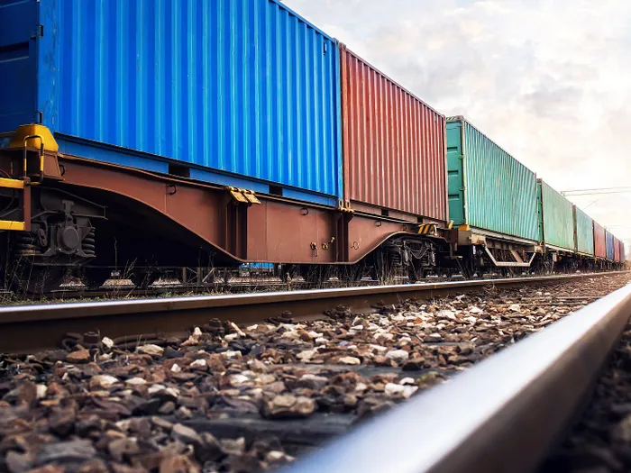 Train wagons carrying cargo containers for shipping companies