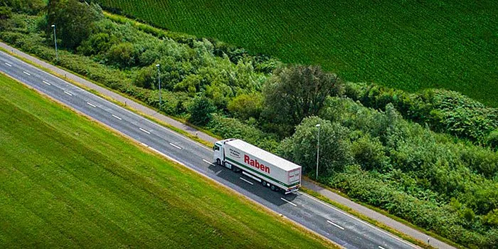 Raben truck on the way to deliver goods through field