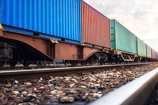 Train wagons carrying cargo containers for shipping companies